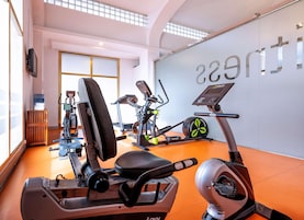 A gym with exercise equipment, a water cooler, and a wall with the word 'gym' visible.