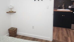 Una cocina moderna con armarios negros, encimera de madera y salpicadero negro.