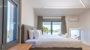 Habitación de hotel con cama, un banco de madera, un escritorio y vistas al exterior.