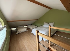 A room with a sloped ceiling, wooden beams, a bunk bed, and a window. - Superb T3 quiet with private parking min Geneva (Vétraz-Monthoux)