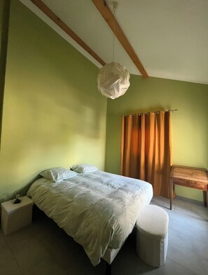 A bedroom with a bed, bedside table, and a hanging light fixture. - Superb T3 quiet with private parking min Geneva (Vétraz-Monthoux)