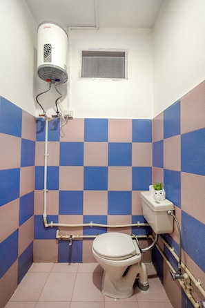 A bathroom with a toilet, a wall-mounted heater, and a window. - Bir Downtown (Baijnath)