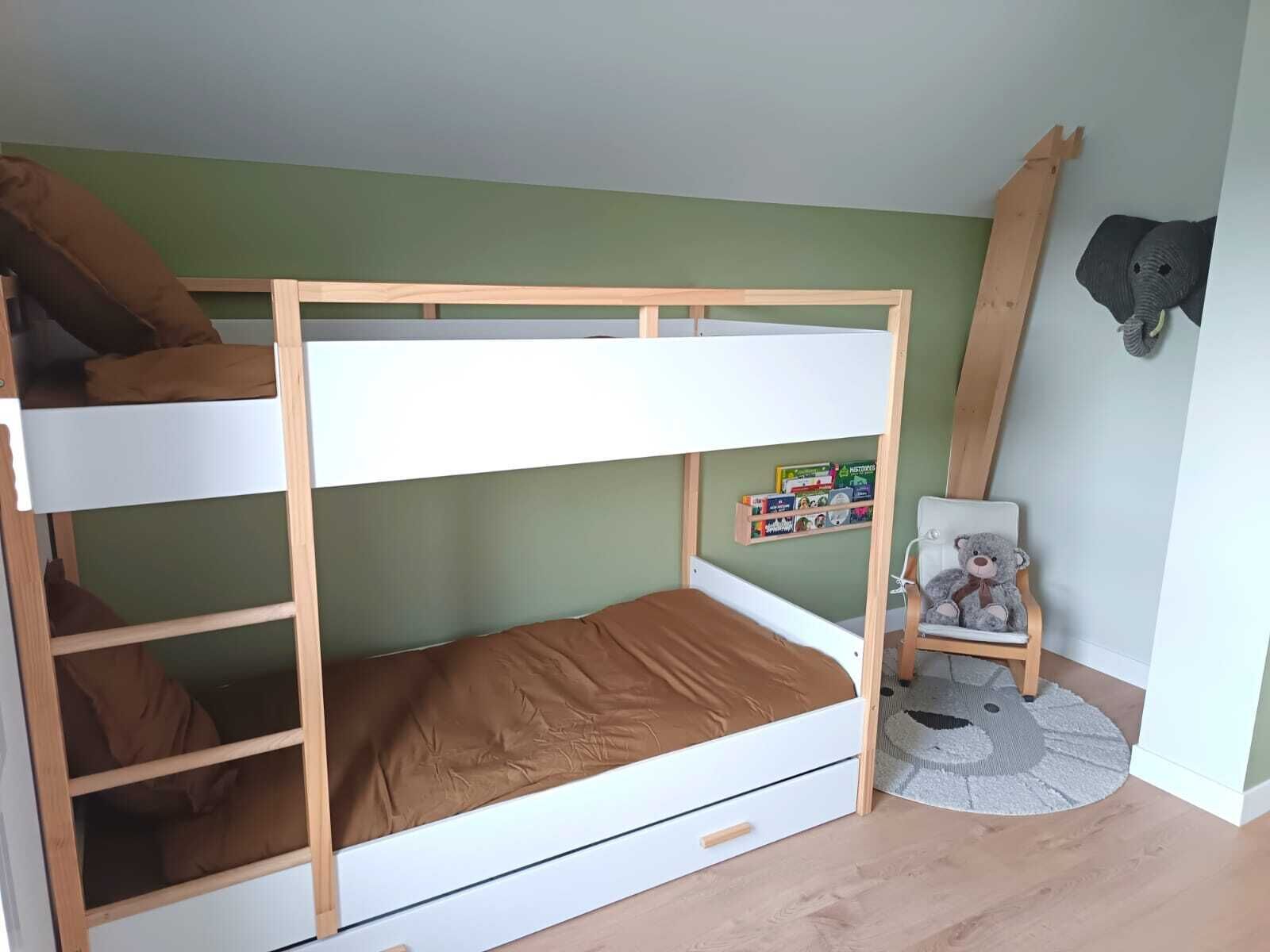 A bunk bed with a wooden frame and a single bed below. There is a small chair with a teddy bear, a shelf with toys, and a wooden ladder leaning against the wall.