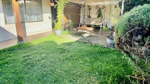 A house with a covered patio area, a lawn, and various potted plants. - Curico FULL furnished house, central location, roofed parking lot (Curicó)