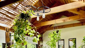 A cozy outdoor seating area with wicker furniture, a glass table, and hanging plants. - Curico FULL furnished house, central location, roofed parking lot (Curicó)