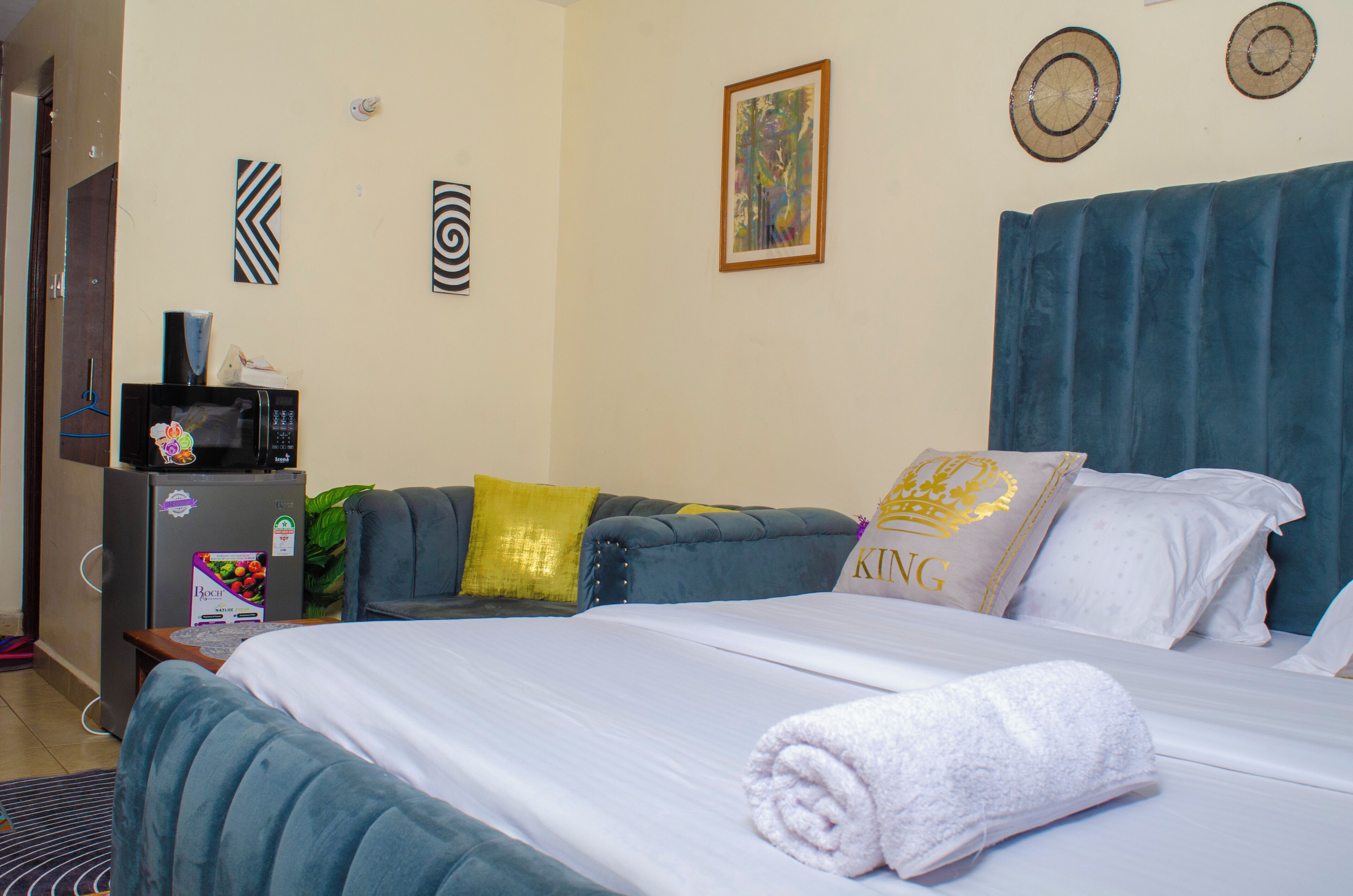 Una habitación de hotel con cama, sofá, microondas y refrigerador.