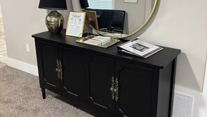 A black console with a gold-framed mirror, a black lamp, and a welcome sign. - Elvis, Blues & BBQ: 4BR Home Just Outside Memphis, Minutes from USA Ball Stadium (Millington)