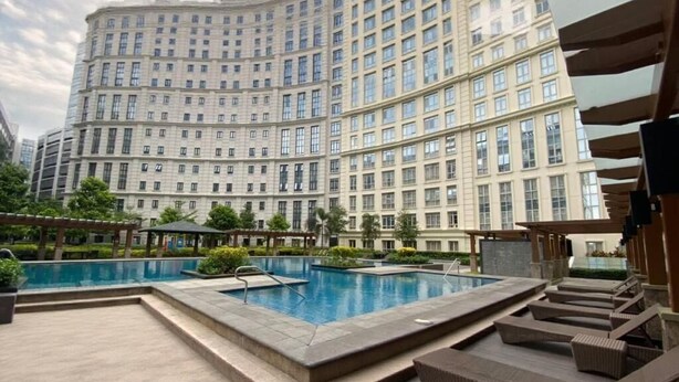 A large hotel with a swimming pool and outdoor seating. - Skyline Suites 81 Newport Condotel NAIA T3 (Pasay City)