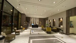 A spacious lobby with a reception desk, seating areas, and a large mirror. - Skyline Suites 81 Newport Condotel NAIA T3 (Pasay City)
