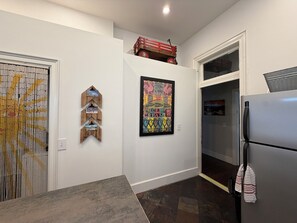 Eine Küche mit Kühlschrank, einer Holzdeko und einem farbenfrohen Poster.