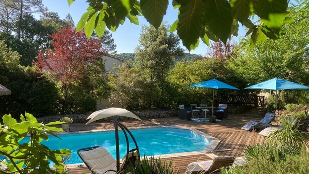 A backyard with a swimming pool, wooden deck, lounge chairs, and umbrellas. - La Maison Bleue, your exceptional break in the heart of the Ardèche Gorges (Salavas)