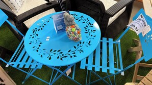 A blue table with a decorative stone centerpiece, surrounded by wicker chairs and a blue chair with a metal frame. - Charming 1-bedroom Apartment in San Juan, Puerto Rico (San Juan)