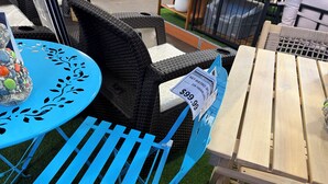 Outdoor furniture with a blue chair and a wooden table, both with price tags. - Charming 1-bedroom Apartment in San Juan, Puerto Rico (San Juan)