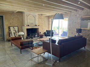 A spacious living room with a fireplace, a sofa, a coffee table, and a lamp. - Country house near St Emilion (Montcaret)