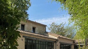 Un bâtiment doté d’un toit en tuiles, de grandes fenêtres et d’une cour intérieure.