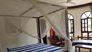 A room with a bed, a chair, and a table. - Ristash Green Resort Mtwapa (Mtwapa)