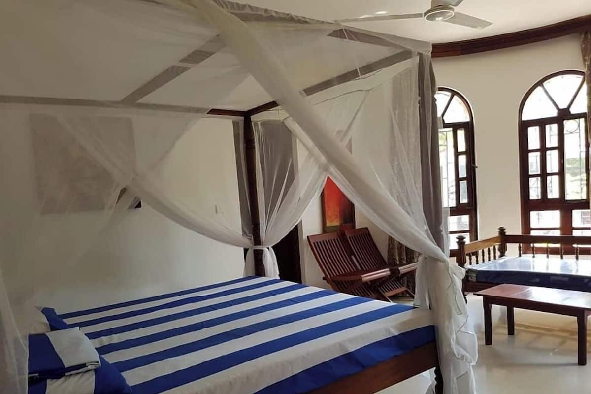 Een kamer met een bed, een stoel en een tafel.
