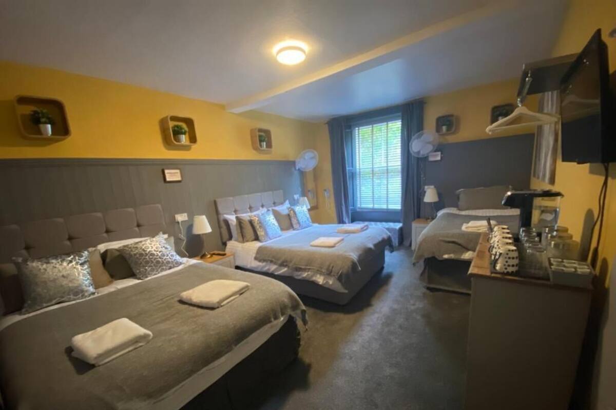 Habitación de hotel con dos camas, un escritorio y una zona de estar.