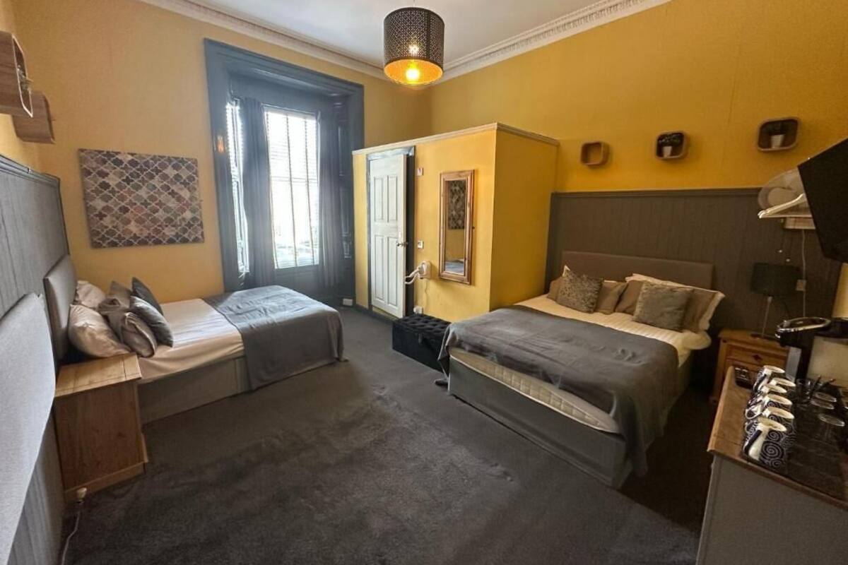 Un dormitorio con dos camas, un armario, un escritorio y una ventana con persianas.