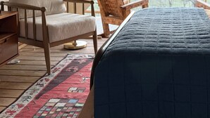 A tented room with a bed, a chair, a lamp, and a view of the outdoors. - Secluded and romantic:  The perfect glamping getaway guests are loving! (Siloam Springs)