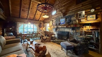 L’intérieur d’un chalet confortable, avec une cheminée, des meubles en bois et une décoration rustique.