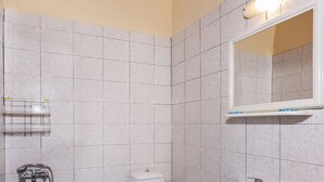 Une salle de bain avec des toilettes, un lavabo et une douche.