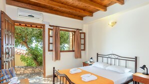 A bedroom with a bed, a nightstand, a table with a cup, and a view of the outdoors. - Villa Maria Studio 6 (Ligres)