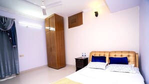 A bedroom with a bed, a wardrobe, a nightstand, and a ceiling fan. - Spacious 3BR Apartment in Dhanmondi (Dhaka)