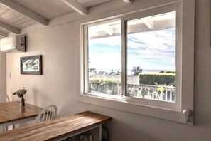 Una habitación con un ventanal grande que ofrece vistas a un jardín ajardinado y un paisaje distante.