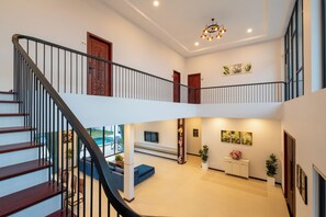 A spacious interior with a staircase, a reception area, and a pool view. - Blanc Smith Private Villa (Siem Reap)
