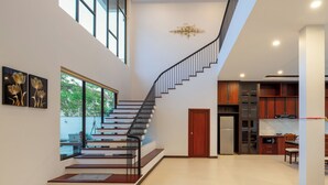 Un interior moderno con una escalera, una cocina y una zona de comedor.