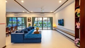 Una sala de estar moderna con un sofá azul, una mesa de centro y un cuadro en la pared.