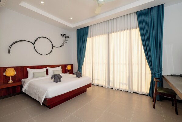 A bedroom with a bed, nightstands, a desk, and a chair. - Blanc Smith Private Villa (Siem Reap)