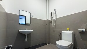 Une salle de bain moderne équipée de toilettes, d’un lavabo et d’une douche.