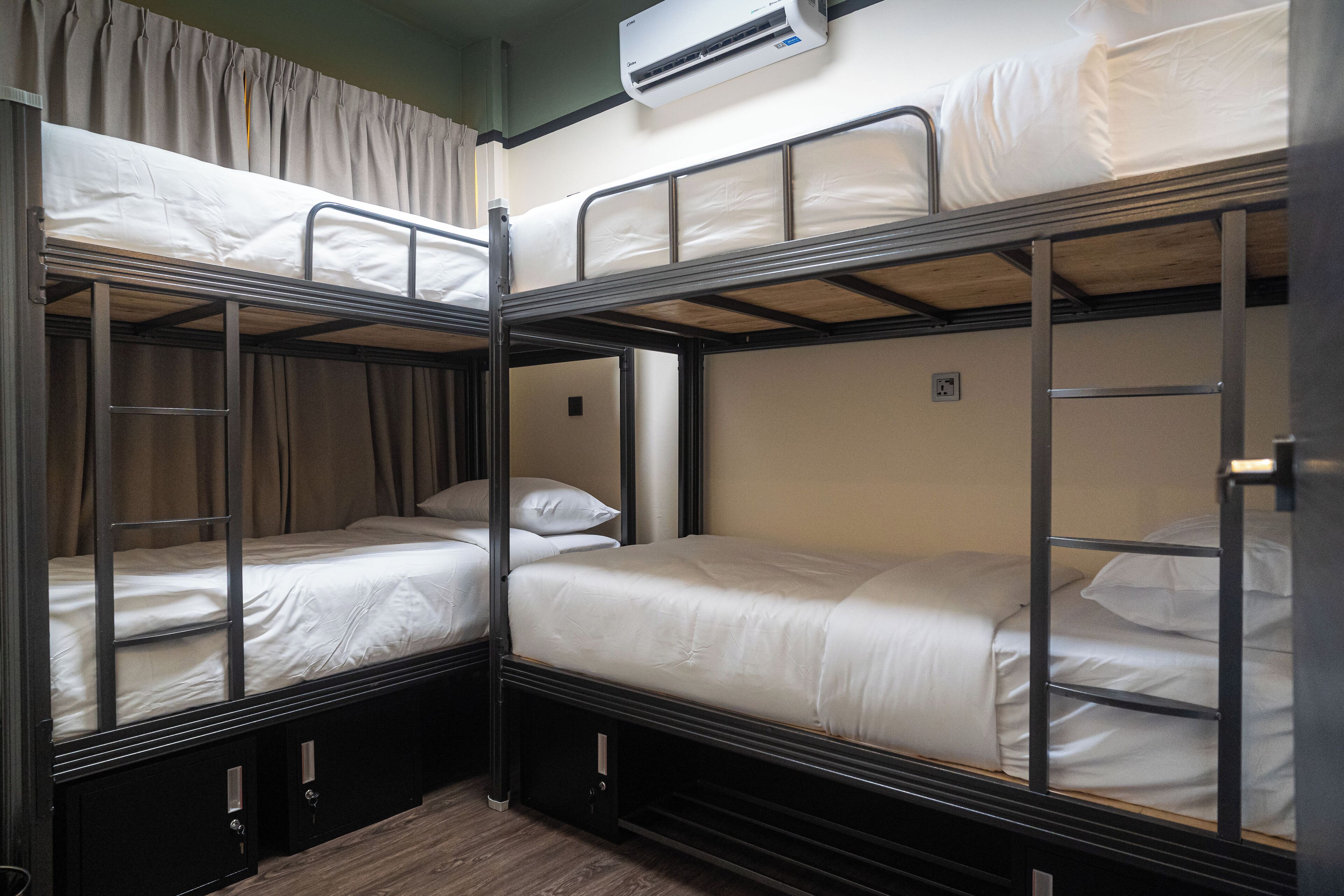 A bunk bed room with a ladder, a power outlet, and an air conditioning unit.