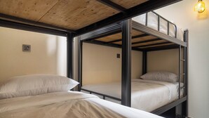 Une chambre avec un lit superposé, un plafond en bois et un seul luminaire.