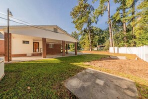 A residential property with a covered porch, a brick exterior, and a grassy yard. - The Newberry Opera House (Newberry)