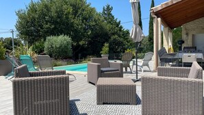 An outdoor patio area with wicker furniture, a pool, and a barbecue setup. - Country house surrounded by lavender fields and vineyards (Grignan)