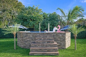 Backyard pool with a stone surround, steps, and tropical landscaping. - Olive Palm Retreat with pool (Miami)