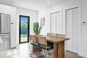 Dining table by the door to the backyard. - Olive Palm Retreat with pool (Miami)