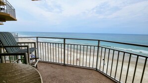 Ein Balkon mit Blick auf Strand und Meer.