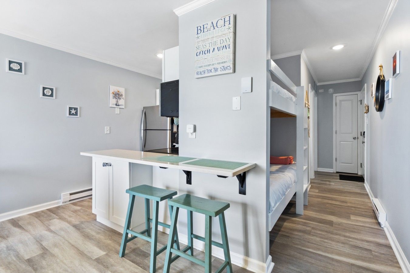 A compact room with a kitchenette, a bed, and a small seating area.