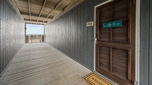 Un pasillo de madera con una puerta de madera que dice 'Sea Breeze' y el número '166' en la pared.