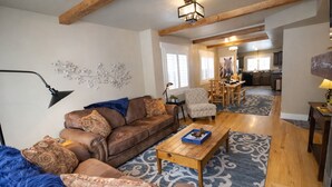 A spacious living room with a brown leather sofa, patterned cushions, a blue furry rug, and a wooden coffee table. - Park City Adventure Retreat Walk to Dining and Skiing 470 (Park City)