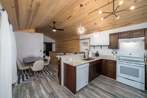 Una cocina moderna con armarios de madera, lavavajillas integrado y una cocina grande.
