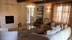 Ein modernes Wohnzimmer mit Kamin, gemütlicher Sitzgruppe und einer Deckenleuchte.