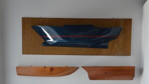 Une pièce comprenant une chaise en bois, un tableau abstrait accroché au mur et une étagère en bois.
