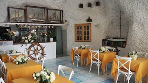 Un restaurant avec des tables dressées pour le service, un bar et une décoration sur le thème de la marine.