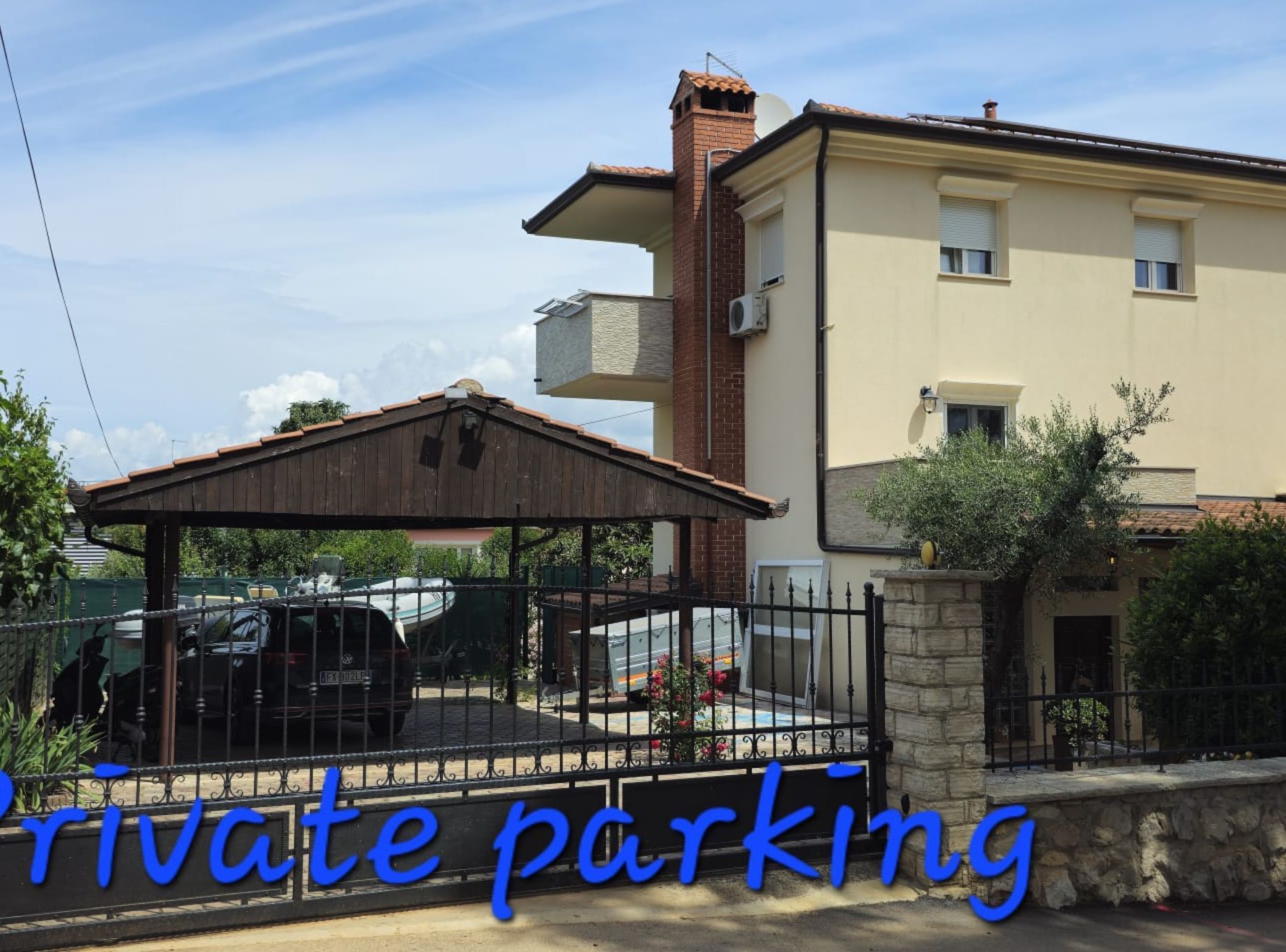 A building with a covered parking area and a stone wall.