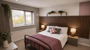 A bedroom with a bed, bedside tables, a radiator, a window with blinds, and a plant. - Chester Charm - Spacious 3 Bedroom House (Chester)